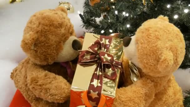 Funny brown moving teddy bears that hold a box with a gift in their paws. Christmas decorations in mall — Stock Video