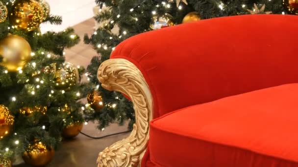 Teil des roten Stuhls des Weihnachtsmannes oder des Nikolauses in der Nähe des Weihnachtsbaums im Einkaufszentrum. Einkaufszentrum mit Weihnachtsdekoration — Stockvideo