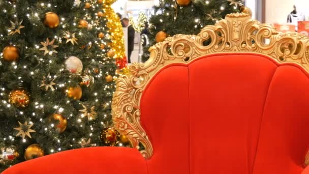 Nuremberg, Alemania - 3 de diciembre de 2018: Silla roja de Santa Claus o San Nicolás cerca del árbol de Navidad en el centro comercial. Centro comercial decoración de Navidad — Vídeo de stock