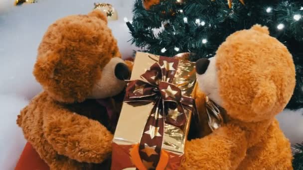 Grappige bruin bewegende teddy beren die houden van een doos met een gift op hun poten. Kerstversiering in winkelcentrum — Stockvideo