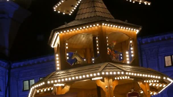 Mercado de pueblo de Navidad en el palacio imperial de residencia en Munich, Alemania. Parte del antiguo molino de Navidad en las luces, en el que hay figuras de madera que representan la Navidad . — Vídeos de Stock