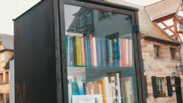 Furth, Duitsland - 3 December 2018: De wereld beroemde bookcrossing beweging in Duitsland. Speciale schappen met boeken geschreven in het Duits, die op de straat staat. — Stockvideo