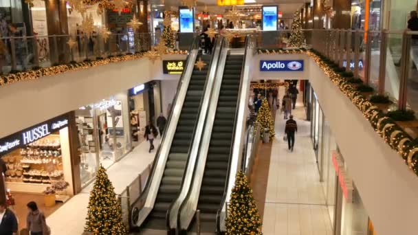 Nuremberg, Germany - December 3, 2018: Two escalators in shopping centre which move up one another down Christmas decor of the mall — Stock Video