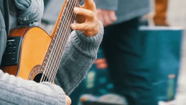 Nuremberg, Alemanha - 1 de dezembro de 2018: Profissional de guitarra de rua tocando habilmente guitarra acústica na rua. Mãos de guitarrista tocando uma guitarra de madeira — Vídeo de Stock