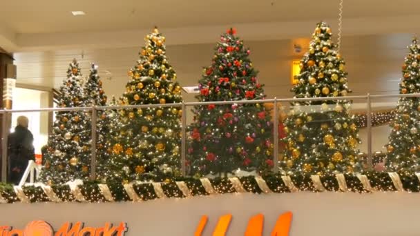 Nürnberg, Németország - 2018. December 1.: Gyönyörűen díszített karácsonyfa nagy arany, piros, ezüst golyó, csillag, a koszorúkat és a hó állandó, a bevásárlóközpont, vagy a bevásárlóközpont — Stock videók