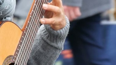Nürnberg, Almanya - 1 Aralık 2018: Street gitar ustaca sokakta akustik gitar çalmak oynayan profesyonel. Ahşap bir gitar gitarist eller