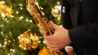 Nürnberg, Almanya - 1 Aralık 2018: bir saksofoncu Noel ağaçları arka üzerinde alışveriş merkezi veya alışveriş merkezi altın bir saksofon çalmaya