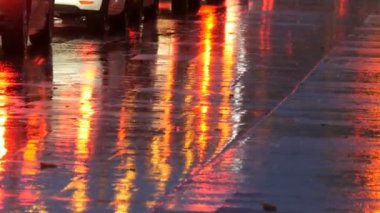 Arabalar trafikte, farlardan asfalt, yağmur altında görüntüleyin. Yağmur su birikintileri geceleri vurur. Arabalar ışıkların yansıması