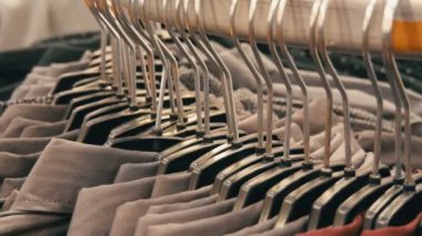 Satır erkek giyim mağazası alışveriş merkezinde büyük bir askı üzerinde çeşitli moda erkek gömlek.