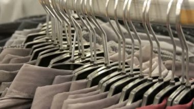 Satır erkek giyim mağazası alışveriş merkezinde büyük bir askı üzerinde çeşitli moda erkek gömlek.