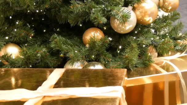 大礼品盒 在商场的圣诞树下呈现金色的礼物 圣诞节和新年礼物装饰 礼品金盒与金色缎带 — 图库视频影像