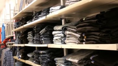 Nürnberg, Almanya - 3 Aralık 2018: Hangi yalan bir satır katlanmış modaya uygun kot pantolon raflarda olan büyük bir sayaç. Alışveriş merkezinde Jeans Mağazası