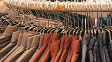 Satır erkek giyim mağazası alışveriş merkezinde büyük bir askı üzerinde çeşitli moda erkek gömlek.