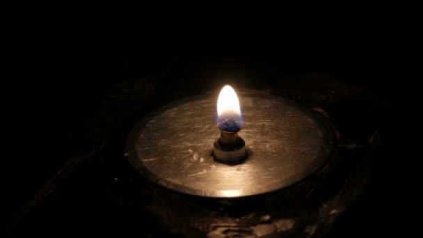 Lonely fireproof burning candle in a church on black background — Stock Video