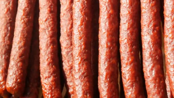 A row of smoked sausages are hanging on the showcase of a butcher shop — Stock Video