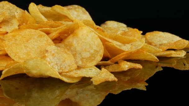 Kadın eller patates cips rastgele siyah bir arka planda dağınık bir ayna yüzeyi üzerinde yalan almak. Zararlı yiyecekler, Fast Food — Stok video