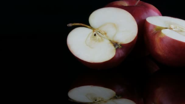 Hermosas manzanas rojas jugosas maduras en la superficie del espejo y fondo negro. Frutas, alimentos saludables, dieta . — Vídeo de stock