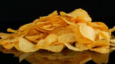 Kadın eller patates cips rastgele siyah bir arka planda dağınık bir ayna yüzeyi üzerinde yalan almak. Zararlı yiyecekler, Fast Food.