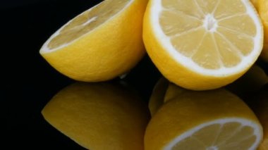 Siyah arka planda siyah ayna yüzeyinde büyük taze sarı limon görünümü yakın.
