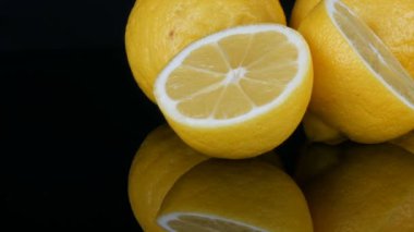 Siyah arka planda siyah ayna yüzeyinde büyük taze sarı limon görünümü yakın.