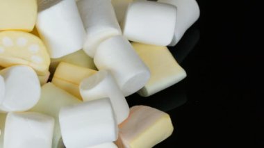 Eller ayna yüzeyi ve siyah arka plan üzerinde çok renkli mini Marshmallow şekerler almak. Diyabet sorunu ve tatlı aşırı yeme