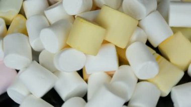 Ayna yüzeyi ve siyah arka plan üst görünümü yavaş renkli mini Marshmallow şekerler rotasyon. Diyabet sorunu ve tatlı aşırı yeme.