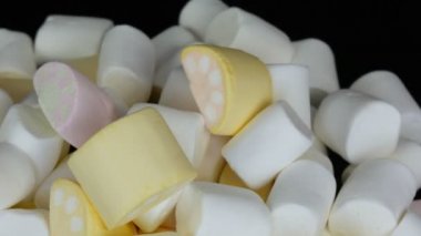 Ayna yüzeyi ve siyah arka planda yavaş renkli mini Marshmallow şekerler rotasyon. Diyabet sorunu ve tatlı aşırı yeme.