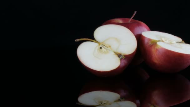 Hermosas manzanas rojas jugosas maduras en la superficie del espejo y fondo negro. Frutas, alimentos saludables, dieta . — Vídeo de stock