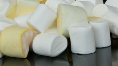 Ayna yüzeyi ve siyah arka planda yavaş renkli mini Marshmallow şekerler rotasyon. Diyabet sorunu ve tatlı aşırı yeme.