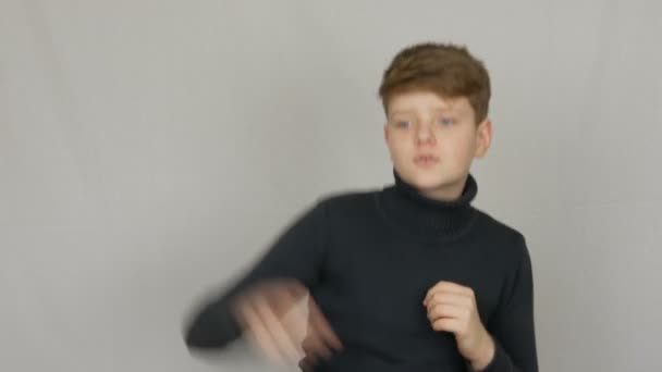Komik bir sarışın ve mavi gözlü genç çocuk portre beyaz arka planda kameranın önünde komik ve eğlenceli dans. Gençlerin duyguları — Stok video