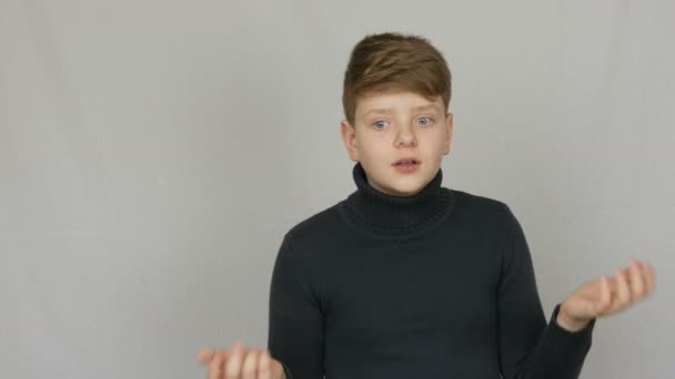 Beyaz arka planda jestleri ve yüz ifadeleri ile kınama gösteren komik bir sarışın ve mavi gözlü genç çocuk portresi. Gençlerin duyguları — Stok video