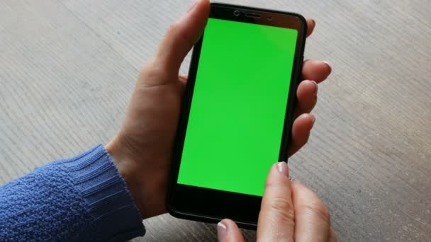 Chroma kulcs vagy zöld képernyő-ra egy fekete smartphone-ban női kezek-val egy jól-ápolt manikűr-ra egy fából készült asztal háttér — Stock videók