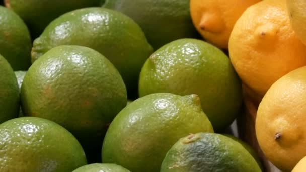 Rijpe limoen groene en gele citroen op de markt teller. — Stockvideo