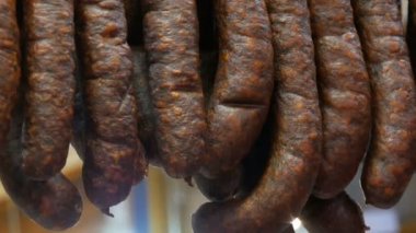Tütsülenmiş sosis bir satırı bir kasap dükkanı Vitrinde asılı