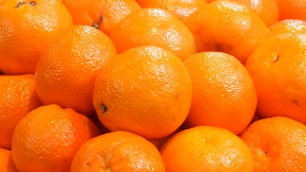 Прекрасні стиглі апельсини на ринковій стійці. Помаранчевий фон фруктів — стокове відео