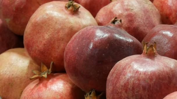 시장 카운터에 있는 큰 잘 익은 빨간 석류 과일. — 비디오