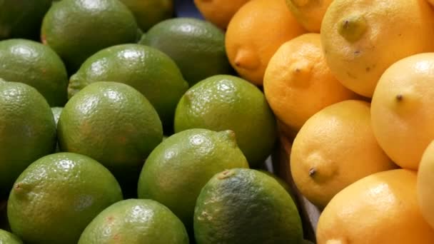 시장 카운터에 잘 익은 라임 녹색과 노란 레몬. — 비디오