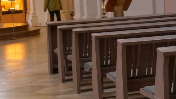 Insida en tom katolsk kyrka. Trä bänk för församlings medlemmar. — Stockvideo