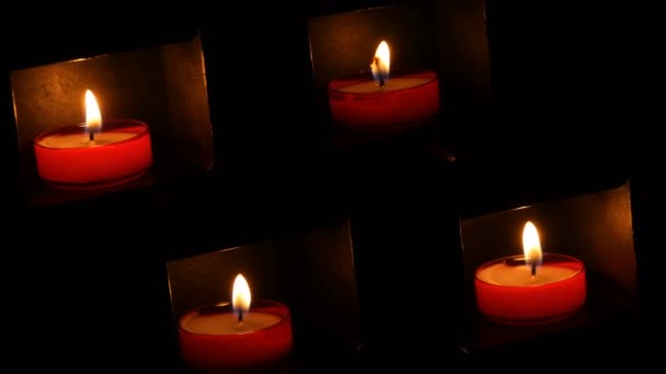 Quemando hermosas velas redondas rojas de oración en un nicho especial en la oscuridad de una iglesia católica . — Vídeo de stock