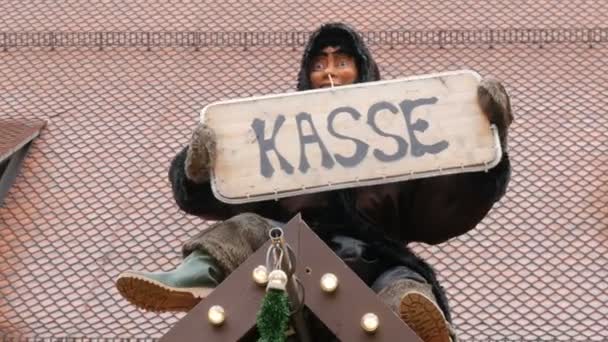 Lustige bewegliche Puppe sitzt auf einem Weihnachtsständer und hält in der Hand ein Schild mit der Aufschrift "Kassiererin". — Stockvideo