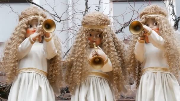 Avrupa 'da çocuk Noel pazarında Kiosk çatısında kar beyaz elbiseler borular ile üç hareketli melek bebek. — Stok video