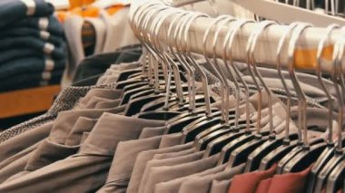 Satır erkek giyim mağazası alışveriş merkezinde büyük bir askı üzerinde çeşitli moda erkek gömlek.