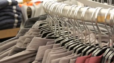Satır erkek giyim mağazası alışveriş merkezinde büyük bir askı üzerinde çeşitli moda erkek gömlek.