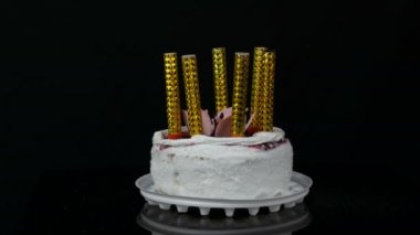 Kadın üzerinde krem ve Hindistan cevizi gevreği ile süslenmiş kiraz reçel ile güzel bir şık tatlı taze beyaz kek üzerinde hafif mum eller. Siyah arka planda Doğum günü pastası.