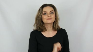 Güzel seksi kadın siyah bir elbise kamerayı beyaz bir arka plan stüdyo hava öpücük gönderir.