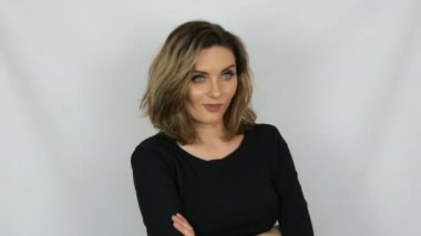 Reproachfully görünüyor siyah bir elbise güzel bir genç seksi zarif kadın portre, gözlerini rulo, onu kaşları, kavgalar yükseltir ve beyaz bir arka plana karşı bir lanet el gösterir.