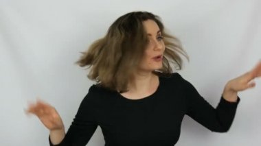 Güzel bir genç seksi kadın şarkı söyleyene dans ve having fun stüdyoda beyaz bir arka plan üzerinde siyah elbiseli portresi.