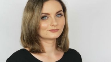 Güzel seksi kız akan saç ve mavi gözleri ile bir kaltak Sitemkâr beyaz bir arka planda kameraya bakıyor.