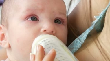 İki aylık bebek anne silah yatıyor ve bir meme süt şişeden berbat. Childs'ın yüz görünümü kapatın