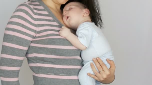 Engraçado bebê recém-nascido de dois meses dorme nos braços de sua mãe. Mãe balança seu filho bebê — Vídeo de Stock